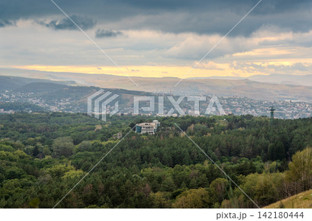 View of the mountains and Kislovodsk from the observation decks of the Kislovodsk Park. Evening sunset over the mountains of Kislovodsk. 142180444