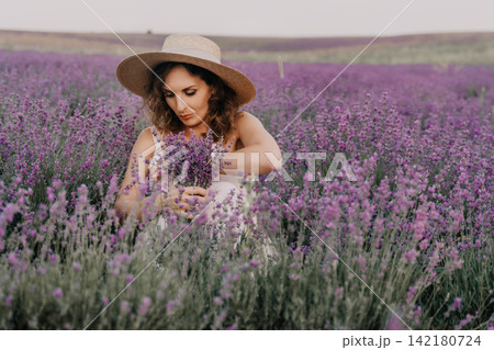 Lavender, woman, summer, picking flowers in a vibrant blooming field, wearing a hat, enjoying a peaceful day in nature Lavender, woman, summer, picking flowers in a vibrant blooming field, wearing a hat, enjoying a peaceful day in nature 142180724