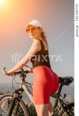 Cyclist bicycle woman, female cyclist posing on mountain bike outdoors during sunny summer day showing fit and healthy lifestyle Cyclist bicycle woman, female cyclist posing on mountain bike outdoors during sunny summer day showing fit and healthy lifestyle 142180743