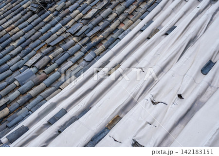 Terracotta tiles and corrugated white material on the roof Terracotta tiles and corrugated white material on the roof 142183151