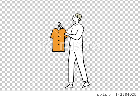 A woman picks up a piece of clothing. A woman picks up a piece of clothing. 142184029