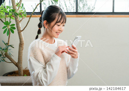 スマホ,スマートフォンのアプリを見る子供,女の子,小学生,中学生,高校生 142184617