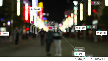Standing two adults wearing coats on blurred night street, showing overlay UI icons over neon signs. Couple, silhouettes, urban, bokeh, storefronts, pedestrians, social 142185214