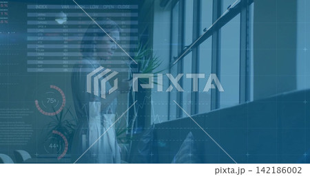 Standing midadult Asian woman in light blouse holding phone viewing data charts near windows plant 142186002