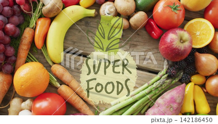 Displaying flat-lay with painted SUPER FOODS label on rustic plank, surrounding fresh produce Displaying flat-lay with painted SUPER FOODS label on rustic plank, surrounding fresh produce 142186450