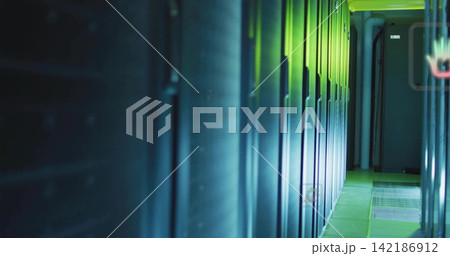 Glowing server cabinets reflecting blue LEDs in data center aisle, revealing floor grates, conduits 142186912