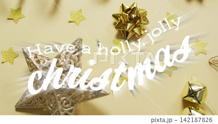 Displaying white cursive christmas greeting on beige background, with silver star, gold bow, bells Displaying white cursive christmas greeting on beige background, with silver star, gold bow, bells 142187826