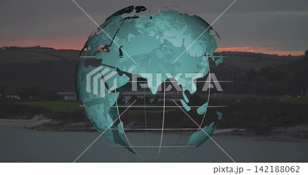 Floating stylized teal globe showing continents, gridlines over calm bay at sunset and rocky shore Floating stylized teal globe showing continents, gridlines over calm bay at sunset and rocky shore 142188062