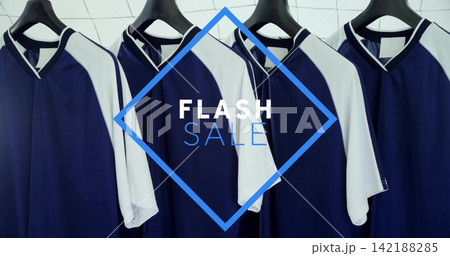 Hanging row of navy-blue white athletic jerseys on rail with black hangers, FLASH SALE overlay Hanging row of navy-blue white athletic jerseys on rail with black hangers, FLASH SALE overlay 142188285