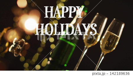 Showing green champagne bottle and two filled flutes on dim tabletop, with HAPPY HOLIDAYS text Showing green champagne bottle and two filled flutes on dim tabletop, with HAPPY HOLIDAYS text 142189636