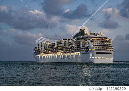 Aerial view of illuminated luxury liner voyage at night. Ship leaving Miami beach port. Cruise ship voyage. Aerial view of cruise in summer vacation. Cruise ship tour and travel at sea Aerial view of illuminated luxury liner voyage at night. Ship leaving Miami beach port. Cruise ship voyage. Aerial view of cruise in summer vacation. Cruise ship tour and travel at sea 142190290
