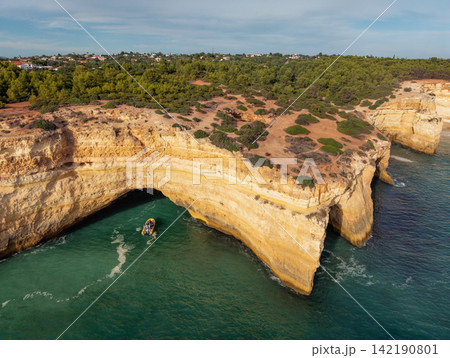Drone View of Benagil Cave Cliffs With Tourist Tour Boat 142190801