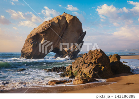 Exploring Penedo do Guincho rock arch at Praia da Santa Cruz during sunset Exploring Penedo do Guincho rock arch at Praia da Santa Cruz during sunset 142190899