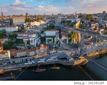 Sunrise drone view of tram on Dom Luis I Bridge beside Gaia waterfront Sunrise drone view of tram on Dom Luis I Bridge beside Gaia waterfront 142191105