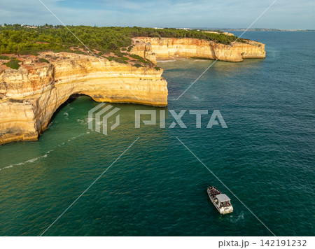 Drone View of a Tourist Tour Boat by Benagil Cave Cliffs Drone View of a Tourist Tour Boat by Benagil Cave Cliffs 142191232