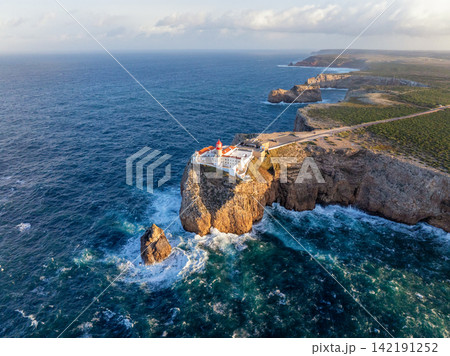 Aerial view of Cabo de Sao Vicente lighthouse at sunrise over the headland 142191252