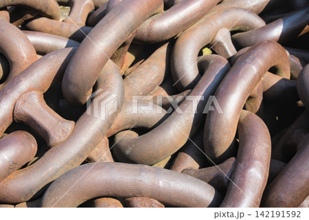 Close view of massive rusted anchor chain links with a warm brown patina Close view of massive rusted anchor chain links with a warm brown patina 142191592