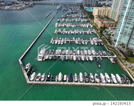 Private boat top view. Harbor marina with luxury sea boat. Yacht club and marina in Miami. Luxury marina with private yacht and boat. Docked yacht boat in harbor. Luxury summer vacation in Miami Private boat top view. Harbor marina with luxury sea boat. Yacht club and marina in Miami. Luxury marina with private yacht and boat. Docked yacht boat in harbor. Luxury summer vacation in Miami 142193413