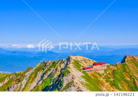 秋の快晴の朝 唐松岳山頂から望む唐松頂上山荘と背景遠くに臨む浅間山方面の山並み 秋の快晴の朝 唐松岳山頂から望む唐松頂上山荘と背景遠くに臨む浅間山方面の山並み 142196221