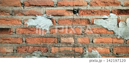 Rustic red brick wall with a weathered appearance. Rustic red brick wall with a weathered appearance. 142197120