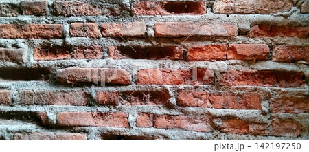 Weathered red brick wall with eroded mortar and spiderwebs. Weathered red brick wall with eroded mortar and spiderwebs. 142197250