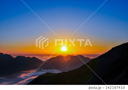 秋の夕暮れ 唐松岳から望むグラデーションの美しい夕空と猫又山に沈みゆく太陽の風景 秋の夕暮れ 唐松岳から望むグラデーションの美しい夕空と猫又山に沈みゆく太陽の風景 142197410