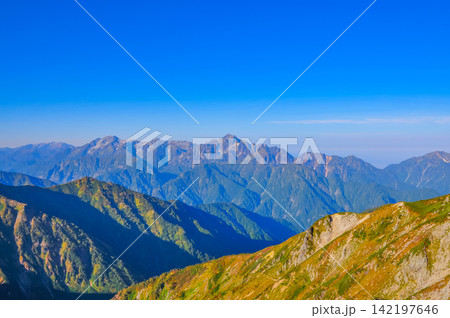 秋の快晴の朝 唐松頂上山荘前から朝日に照らされた剱岳と立山連峰を望む山岳風景 142197646