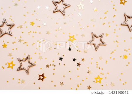 Golden and glittering stars on beige background 142198041