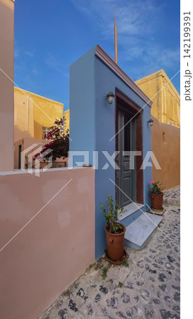 Traditional blue facade entrance door on narrow paved street in Oia village Santorini island Cyclades Greece architecture stock photo Traditional blue facade entrance door on narrow paved street in Oia village Santorini island Cyclades Greece architecture stock photo 142199391