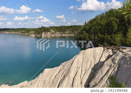 Turquoise lake surrounded by lush green forest and white rocky cliffs under a bright summer sky, creating a peaceful scenic landscape ideal for travel, vacation, and outdoor adventure. Turquoise lake surrounded by lush green forest and white rocky cliffs under a bright summer sky, creating a peaceful scenic landscape ideal for travel, vacation, and outdoor adventure. 142199486