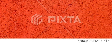 Extreme close up of an orange, coarse textured surface with a bumpy, granular appearance. Extreme close up of an orange, coarse textured surface with a bumpy, granular appearance. 142199617
