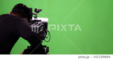 Behind the scenes. BTS of TV commercial movie film or video shooting production which pro camera crew setting up on green screen for chroma key technique in studio. Greenscreen background shooting set Behind the scenes. BTS of TV commercial movie film or video shooting production which pro camera crew setting up on green screen for chroma key technique in studio. Greenscreen background shooting set 142199669