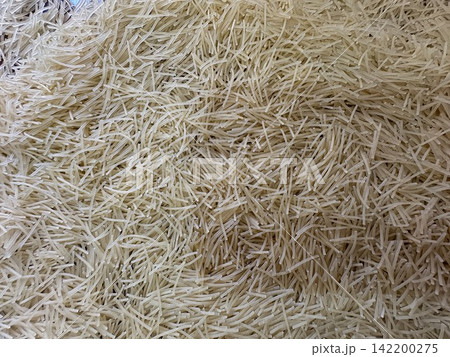 Close-up of dry thin vermicelli noodles pile texture background Close-up of dry thin vermicelli noodles pile texture background 142200275