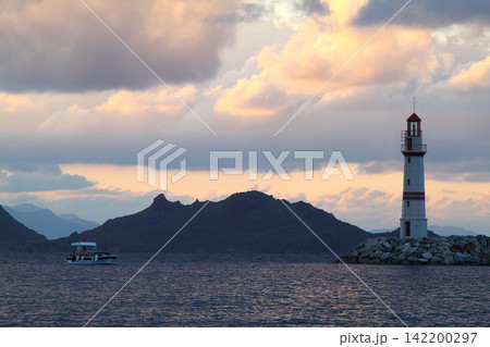 Seascape at sunshine. Lighthouse and sailings on the coast. Seaside town of Turgutreis and spectacular sunshine Seascape at sunshine. Lighthouse and sailings on the coast. Seaside town of Turgutreis and spectacular sunshine 142200297
