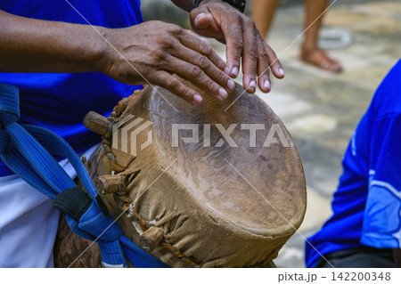 Drummer playing a rustic and rudimentary atabaque Drummer playing a rustic and rudimentary atabaque 142200348