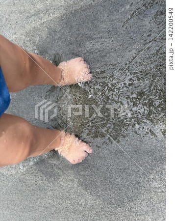 裸足で海水浴を楽しむ子どもの足元 裸足で海水浴を楽しむ子どもの足元 142200549
