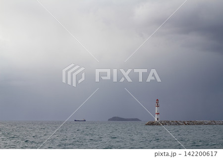 Seascape at sunshine. Lighthouse and sailings on the coast. Seaside town of Turgutreis and spectacular sunshine Seascape at sunshine. Lighthouse and sailings on the coast. Seaside town of Turgutreis and spectacular sunshine 142200617