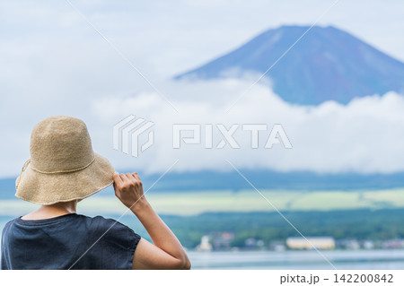後ろ姿の女性と富士山｜山中湖・湖畔から夏の富士山を眺める女性 142200842