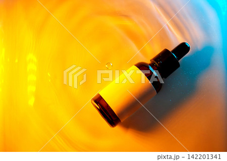 Cosmetic serum dropping into water with ripple effects Cosmetic serum dropping into water with ripple effects 142201341