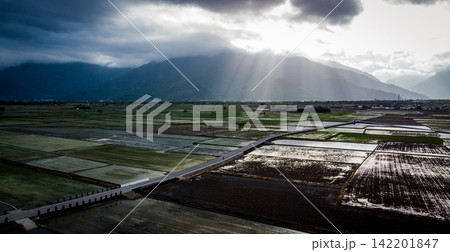 Sunbeams Breaking Through Storm Clouds Over Taiwan Rice Fields and Mountains 142201847