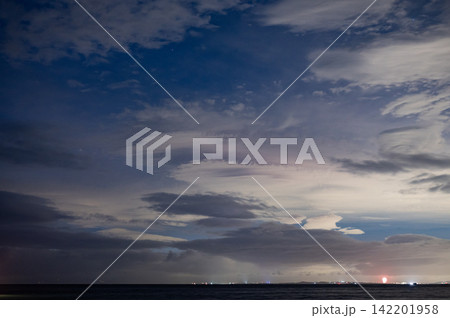 厚い雲間から差し込む夕陽 厚い雲間から差し込む夕陽 142201958
