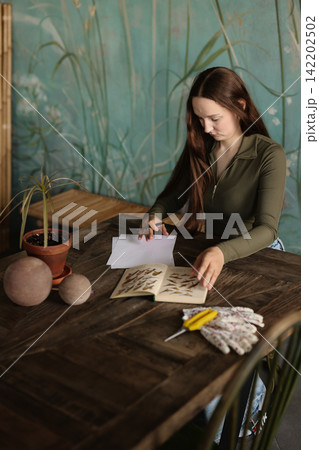 Female artist engaged in plant drawing using watercolors and ink Female artist engaged in plant drawing using watercolors and ink 142202502