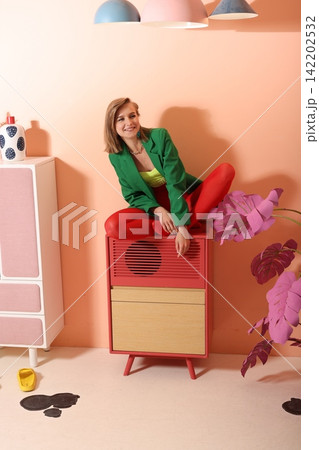 Woman stylist arranging paper flowers in pastel studio Woman stylist arranging paper flowers in pastel studio 142202532