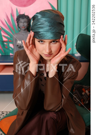 Studio shot of woman in turban and thoughtful expression 142202536