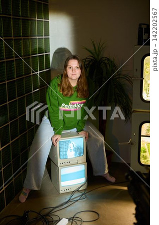 Caucasian woman arranging retro monitors for photoshoot Caucasian woman arranging retro monitors for photoshoot 142202567