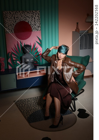 Sophisticated woman enjoying leisure amidst vibrant artistic environment Sophisticated woman enjoying leisure amidst vibrant artistic environment 142202568