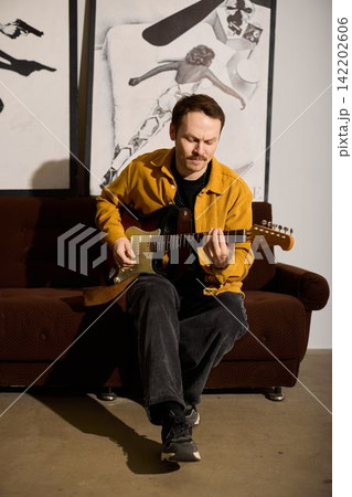 Solo musician immerses in detailed electric guitar practice session Solo musician immerses in detailed electric guitar practice session 142202606