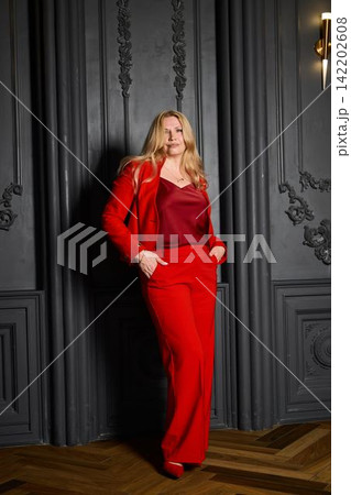 Fashionable woman dressed in red on polished parquet with artistic lighting Fashionable woman dressed in red on polished parquet with artistic lighting 142202608