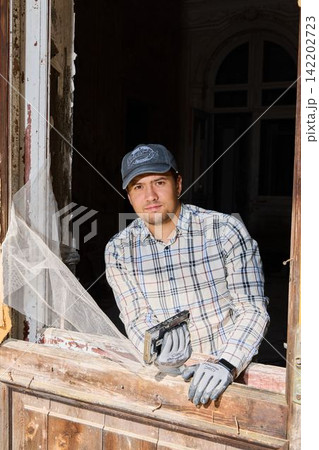Individual observing renovation progress thoughtfully indoors 142202723
