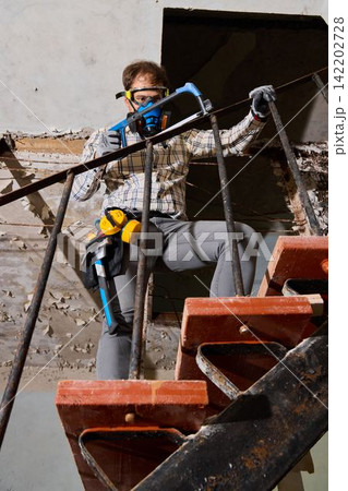 Worker preserves vintage interior using protective gear at dusty site 142202728